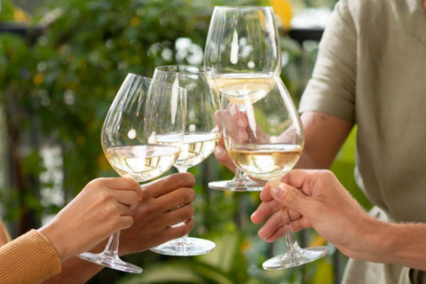 Friends enjoying a vegan wine toast during a celebration, sharing a joyful moment of togetherness and festivity.